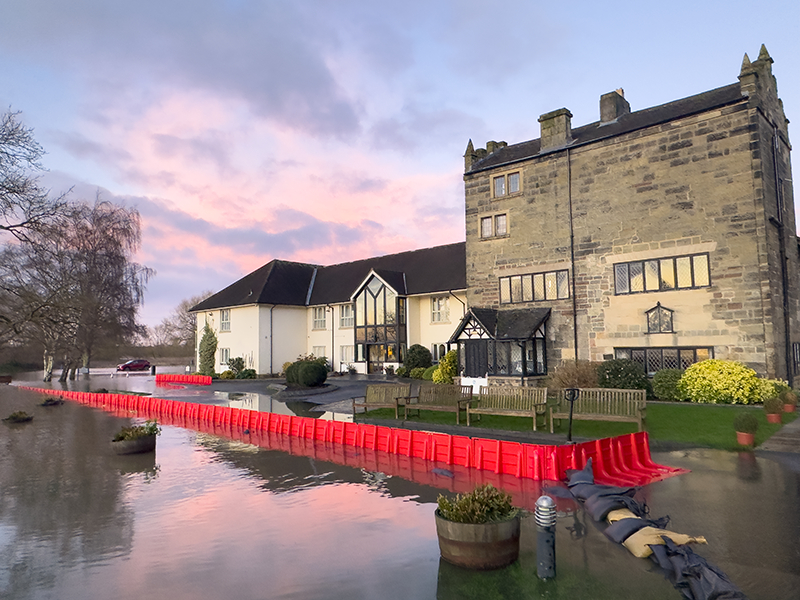 flooding around historic building protected by flood barrers at sunset